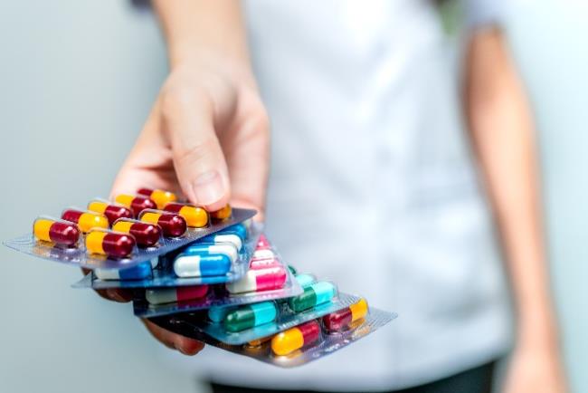 גבר מחזיק סוגים שונים של אנטיביוטיקה, בה המליץ ארגון הבריאות העולמי לא להשתמש במקרי קורונה קלים מחשש לפיתוח של עמידות לתרופה באוכלוסיה